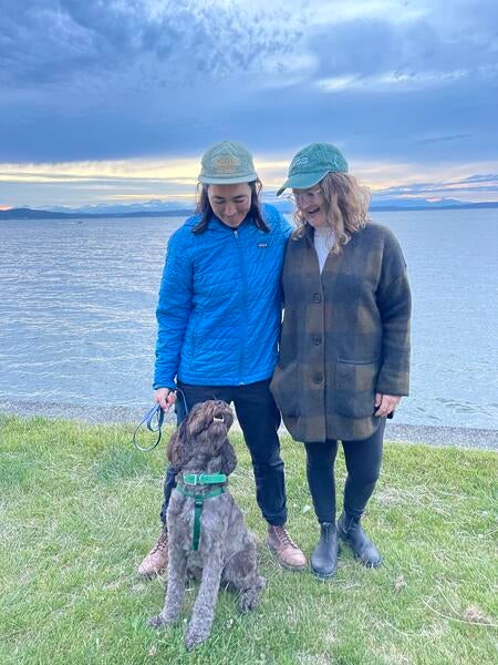 Kelly Kraus Lee, Director of Development, Education and Policy posses with her wife and dog near a lake on a camping roadtrip.  